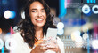 © Prostock-studio - Happy Young Caucasian Woman Smiling While Holding Smartphone Outdoor At Night In Urban Environment. She Is Engaged With Her Device, Displaying A Joyful Emotion. Technology Concept.