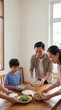 © Debi Kurnia Putra - Asian family enjoying home cooked dinner at wooden table