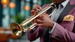 ©  VladaToday - Closeup of a jazz trumpet player’s hands on brass instrument at golden hour into night for music performance and event promotion showing valves, shine and elegant stage atmosphere
