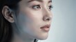 © TransPicHub - A close-up portrait of a young woman looking thoughtfully to the side, highlighting her clear skin and subtle makeup.