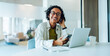 © Julia - Smiling woman at desk with laptop and phone