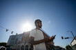 © Rawpixel.com - Man in casual wear using phone outdoors under a clear blue sky.