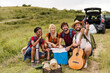 © milanmarkovic78 - Group of friends having a picnic in a grassy field