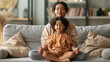 © Julia - Child and parent practice breathing techniques for emotional regulation in a peaceful living room after feeling upset