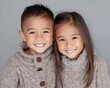 © Anuson - Portrait of two joyful young Asian siblings smiling happily in warm knitted sweaters
