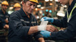 © ViskBx - Industrial worker receiving first aid treatment for a wrist injury from a colleague in a factory setting with safety gear and bandages