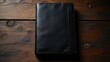 © rahwik - top view flat lay elegant antique black leather journal on rustic dark wood surface for academic or mystery writing concept