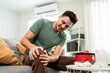 © Kawee - Latino sick man suffering from knee pain in cozy living room at home.