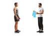 © Ljupco Smokovski - Fitness trainer talking to a male client and holding a blue resistance band