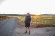 © Nazareno - Man standing on rural road at golden hour sunset
