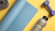 © LAB IMAGE - A rolled-up yoga mat and a water bottle on a yellow background, highlighting the active lifestyle and fitness theme.