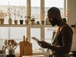 © Muaz - Man using a digital tablet in a sunlit kitchen