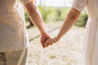 © anatoliycherkas - Couple holding hands, walking outdoors in summer, showing love, togetherness, and connection during a romantic moment