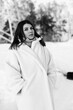 © shymar27 - Black and white winter portrait of a peaceful young woman wearing a cozy white teddy bear coat with eyes closed.