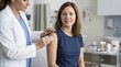 © Xenia - Female doctor preparing a patient for a flu shot injection. Medical professional wiping woman's arm with an alcohol swab in a modern clinic