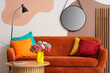 © Pixel-Shot - Interior of stylish living room with brown sofa, colorful cushions, coffee table and mirror