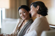 © Milos - Two women engage in a relaxed conversation while seated in a stylish setting, radiating warmth and friendship amid a beautifully nuanced environment highlighting emotional connection.