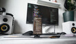 © Aboltin - Minimal coding station featuring professional monitor with source code, organized accessories, speakers and fresh coffee. Bright home office supports software engineering, productivity and creative pr