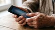 © Marin Studio - Close-up of elderly hands holding a smartphone and interacting with the screen
