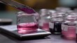 © Justlight - Medium framing of a spatula scraping pink ink from a jar on a workspace scales and labeled jars gently out of focus nearby.