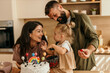 © La Famiglia - Family celebrating toddler birthday decorating cake with parents