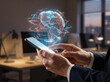 © MONIRUJJAMAN - Worldwide financial data tracking via mobile phone with glowing planet hologram and currency symbols displayed in professional workspace.
