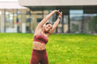 © Prostock-studio - Happy African American Woman Stretching Arms While Enjoying Outdoor Fitness Session, Wearing Athletic Clothes In Green Park Environment, Embracing Health And Wellness Lifestyle.