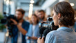 © Denis Yevtekhov - Waiting in a well-lit indoor venue, a group of journalists prepares cameras and microphones for an official arrival, professional atmosphere, clean architecture, journalism, press,