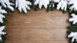 © Bonsales - Rustic wooden plank background framed by snow covered evergreen branches for Christmas and winter holidays