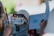 © qunica.com - A plastic skull model wearing sunglasses sits on a table beside drinks and a sketched notebook. The scene shows a casual school study setup with doodles and writing on lined paper.