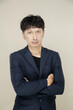 © Pornsak - Confident Asian businessman with arms crossed on neutral background