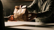 © Pete - Person hands over brown paper bag with takeaway meal. Customer receives food order from server at counter. Indoor scene, casual attire, minimal setup focuses on transaction.