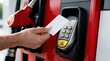 © Pete - Person taps blank credit card on contactless reader at gas pump. Man pays for fuel using modern payment system at petrol station, easy transaction.