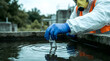 © Mahmuda - environmental scientist collecting water samples | hazardous material testing at plant | industrial water quality monitoring | researcher in hazmat suit sampling