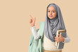 © Pixel-Shot - Little Muslim girl in hijab with school backpack and books pointing at something on beige background