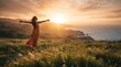 © for you - A happy woman standing on a grassy hill with arms outstretched enjoying the beautiful golden sunset view