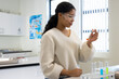 © Wavebreak Media - African-American teen wearing goggles holding pipette checking orange solution near tubes at school