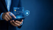 © LECASTLE Studio - Businessman using smartphone with virtual credit card and security shield icon, secure online payment and mobile banking concept with copy space