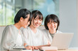 © buritora - Elementary and middle school girls in casual clothes happily looking at a computer with their friends.