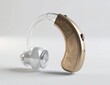 © Nanda - Gold and silver hearing aid device isolated on white.