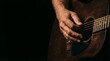© Predicted - Mature man playing acoustic guitar close up on dark background