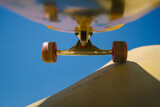 Low angle view of skateboard trucks and wheels above a skate ramp