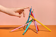 © Tatyana Lavrova/Stocksy - Still life with Hand and Balanced Pencils on Orange Background