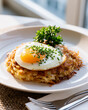 © Thisisbest - Crispy Fried Egg on Top of a Delicious Potato Dish Served on a Plate with Fresh Herbs