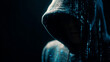© LORD - Mysterious hacker wearing a dark hood surrounded by glowing blue digital binary code in shadow