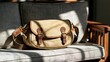 © Roger - Vintage style khaki canvas messenger bag with brown leather trimmings resting on gray fabric sofa with warm natural sunlight shows classic daily carry fashion concept