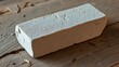 © Neko - Worn coarse sharpening stone on a rustic surface with deep grooves from use.