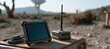 © spyrakot - Rugged tablet and satellite receiver kit on outdoor work mat in remote landscape