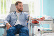 © Serhii - Man smiling while donating blood in clinic
