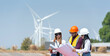 © BESTIMAGE - Team workers training wind turbine power generator sustainability performance brainstorming together at Renewable Energy Plant Group of diverse engineers checking with blueprint at wind farm
